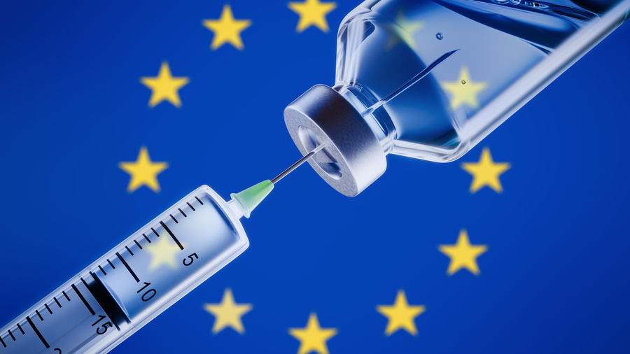 Symbolbild: Impfstoff-Ampulle mit Spritze vor EU-Flagge